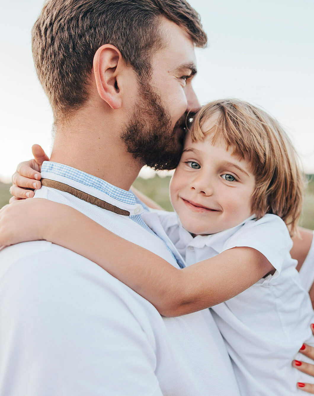 Father hugging child with healthy smiles representing gentle family dental care in Spokane, WA
