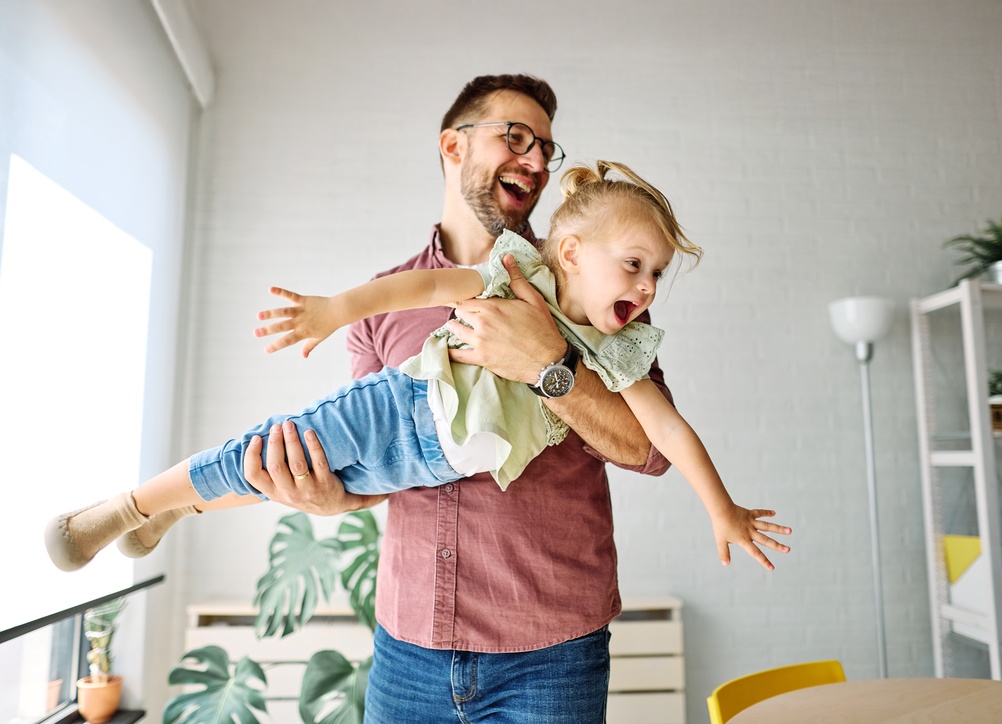 Father and child playing together, representing family-friendly dental care